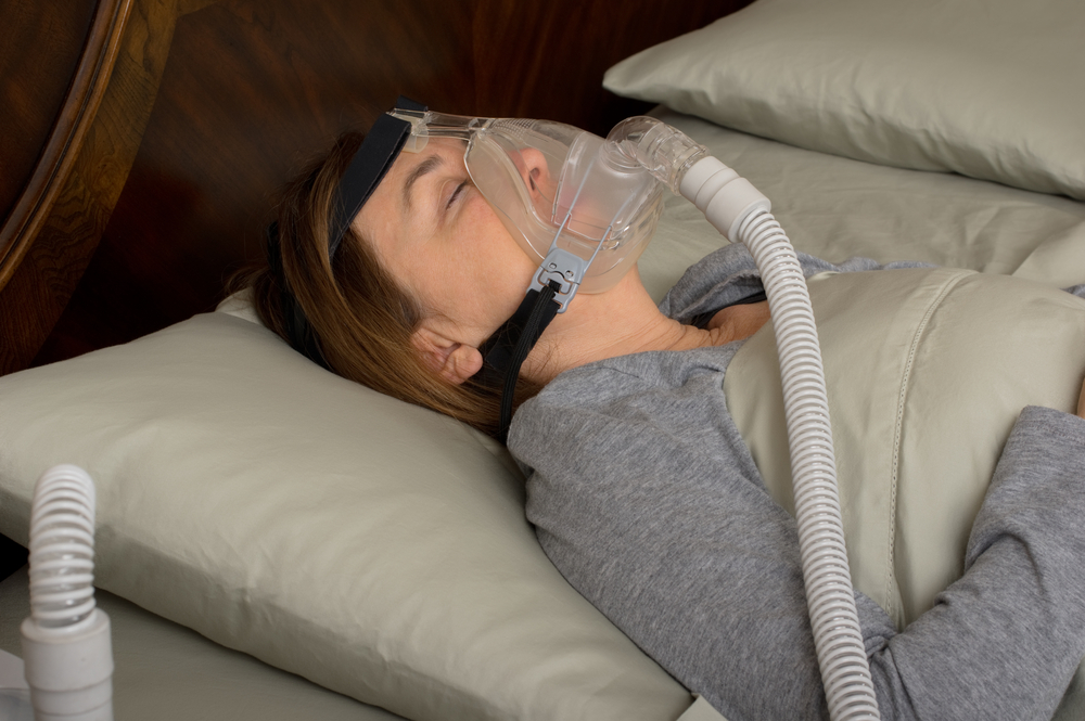 Woman sleeping with CPAP machine on