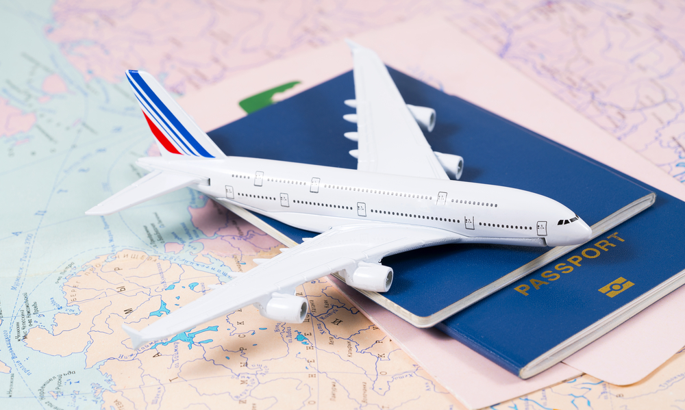 Toy airplane on top of passports with world map background